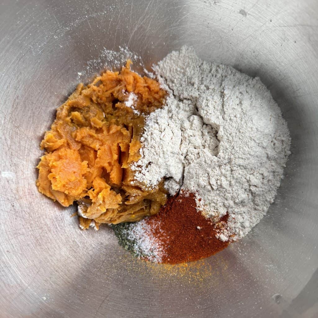 Rajgira atta, mashed sweet potato, and spices arranged in a mixing bowl before kneading the dough.