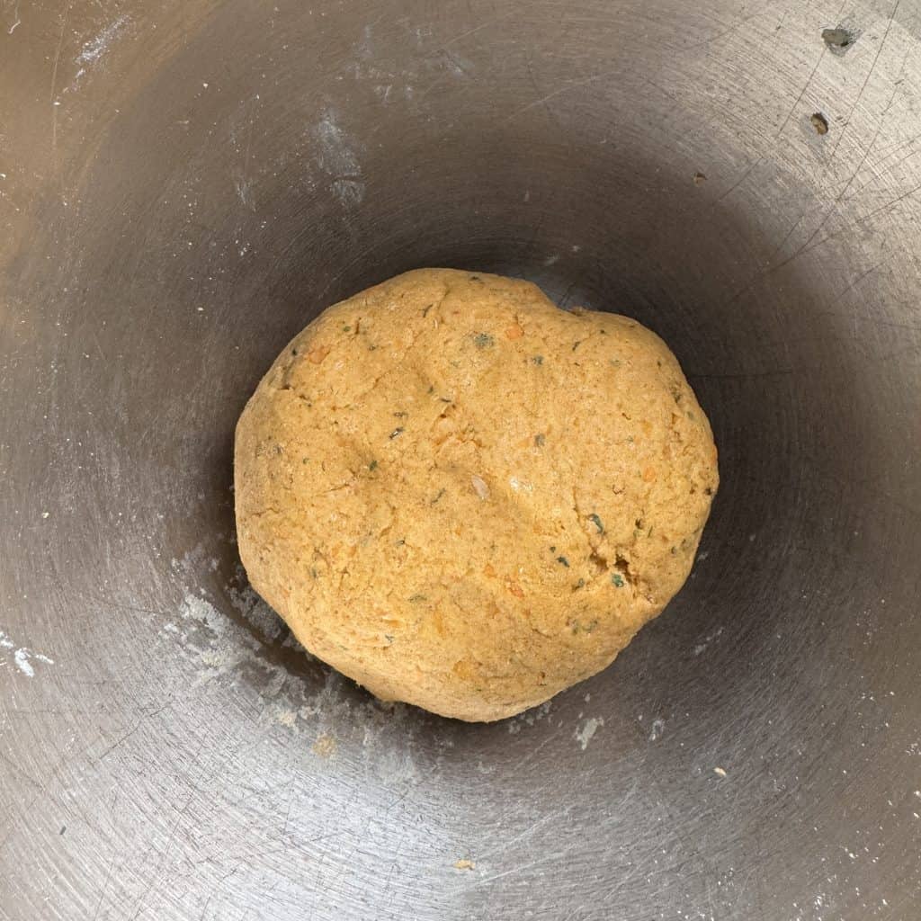 A ball of slightly soft dough made from rajgira flour and mashed sweet potatoes, resting in a steel bowl.