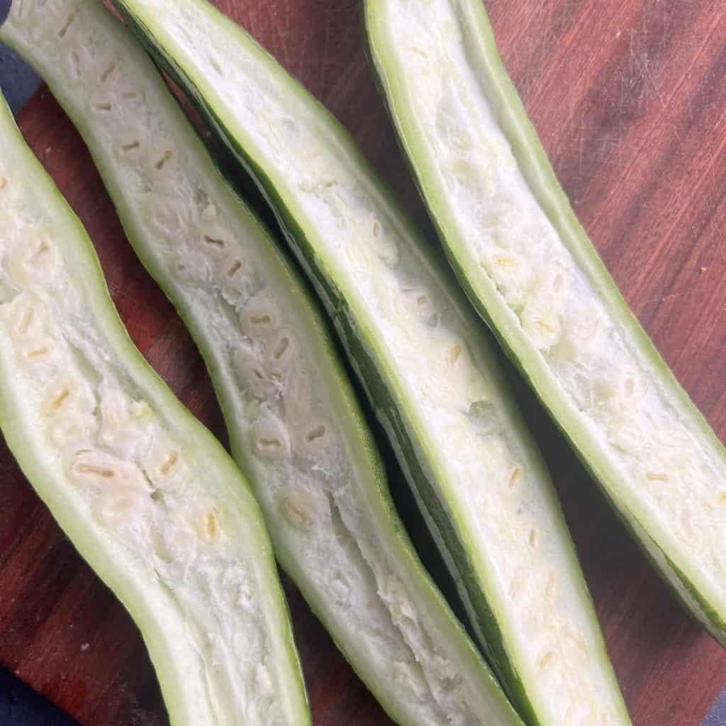Snake gourd cut lengthwise showing inner seeds.