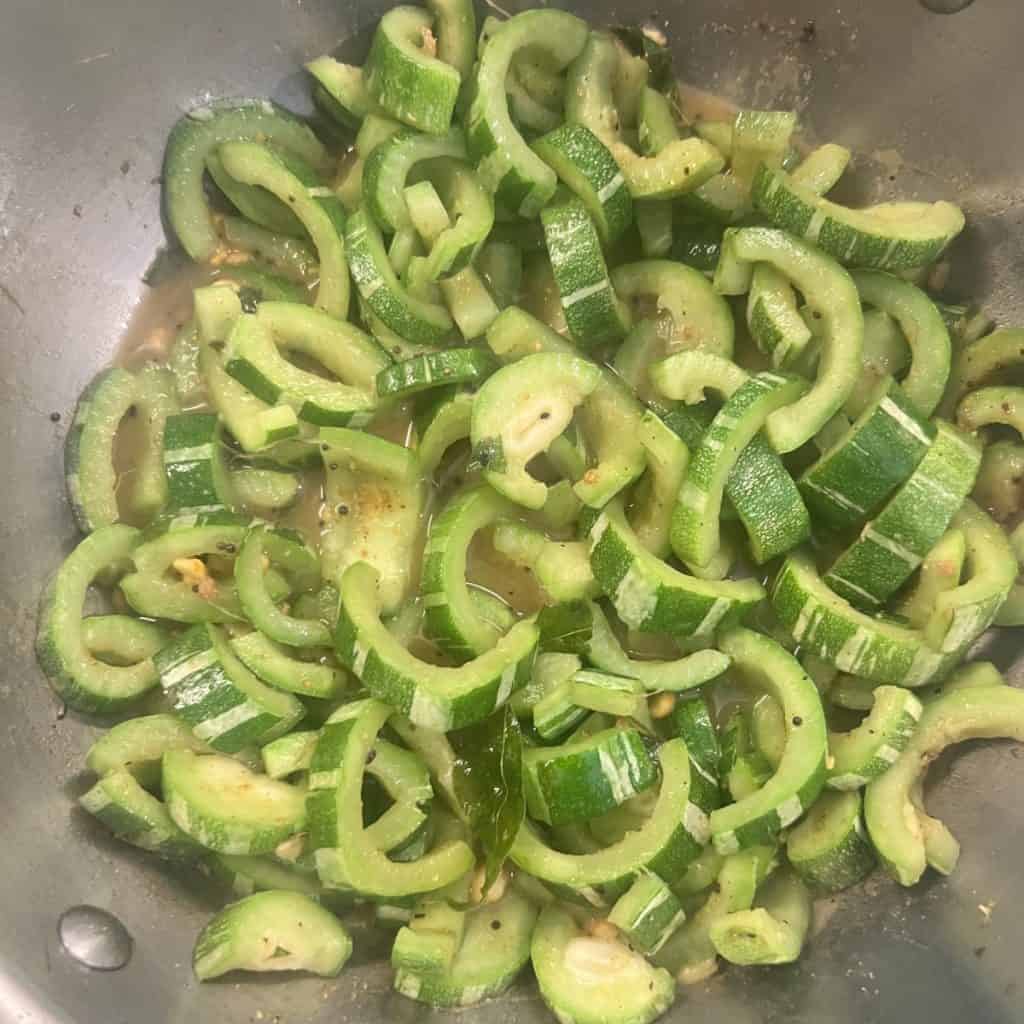 Snake gourd chana dal kootu garnished with coconut in a bowl.